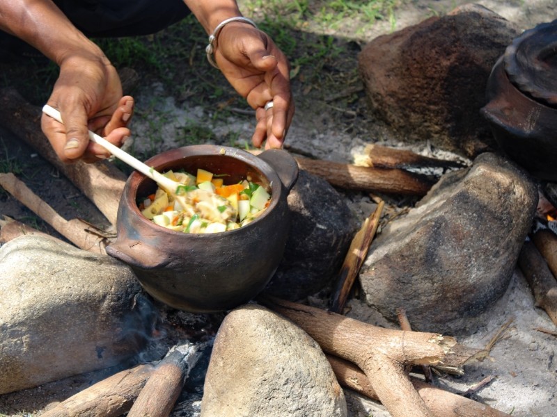 Ras Iroy checking on stew in pot